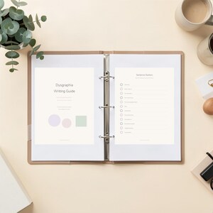 May include: A beige three-ring binder open to two pages. The left page is titled Dysgraphia Writing Guide with a light purple circle, a light pink circle, and a light green square. The right page is titled Sentence Starters with a list of checkboxes.