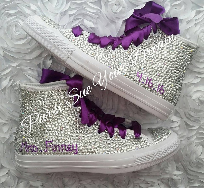 May include: A pair of high-top sneakers completely covered in clear rhinestones with deep purple satin ribbon laces. The text "Purse Sue Your Dream" is written in cursive, and the text "Mrs. Finney" and "4.16.16" are in purple script.