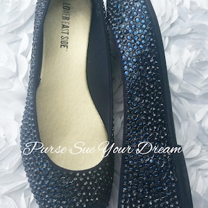 May include: A pair of flat shoes covered in dark blue rhinestones. The interior insole is gold and features the text LOWER EAST SIDE. The text Purse Sue Your Dream is overlaid on the image. The shoes have a rounded toe and a low profile design.
