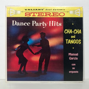 May include: A vintage record album cover featuring a silhouette of a couple dancing. The album is titled "Dance Party Hits: Cha-Cha and Tangos" by Manuel Garcia and his orchestra. The album cover is in red, yellow, and black.