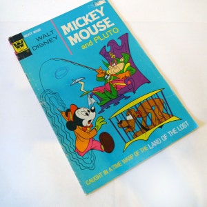 May include: A vintage comic book cover featuring Mickey Mouse and Pluto. The cover is blue with a yellow border and features Mickey Mouse, Pluto, and a green and purple character with a fishing rod. The text on the cover reads "Mickey Mouse and Pluto" and "Caught in a Time Warp of the Land of the Lost."