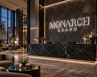 May include: A hotel lobby featuring a large black marble reception desk with the illuminated text MONARCH GRAND on the wall behind it. The space includes polished stone floors, warm accent lighting, and seating areas with round tables.