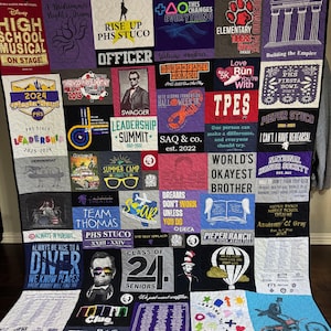 Peut inclure: Une courtepointe souvenir composée de divers t-shirts graphiques présentant des imprimés, logos et textes variés, notamment High School Musical, PHS Stuco et Class of 24. La courtepointe affiche une grille de carrés en tissu coloré.