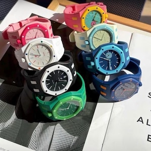 May include: A collection of eight silicone wristwatches in various colours including pink, white, black, green, light blue, dark blue, and yellow. Each watch features an octagonal bezel, a textured dial with hour markers, and a matching silicone strap.