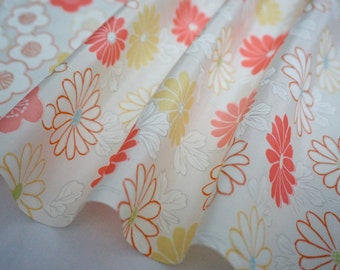May include: White fabric with a repeating pattern of pink and yellow flowers. The flowers have a delicate, hand-drawn look.