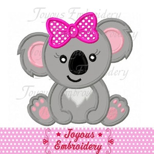 May include: A grey koala with pink ears and a pink bow with white polka dots. The koala is sitting with its arms crossed and has a happy expression.
