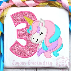 May include: Pink glitter number three with a unicorn head peeking out from behind it. The unicorn has a gold horn, pink and blue mane, and white face. The text "Joyous Embroidery" is at the bottom of the image.