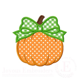 May include: An orange pumpkin embroidery design featuring a white polka dot pattern and a brown stem. A large green and white gingham check bow is positioned at the top of the pumpkin. The design has a thick orange outline and stitching details.