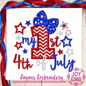 May include: White t-shirt with a patriotic design for the 4th of July. Features a large number 1 in red and white stripes, a blue bow with white stars, and the text "my 1st 4th of July". Includes red, white, and blue stars.