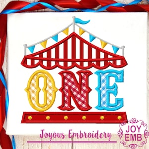 May include: A red and white striped circus tent with yellow and blue flags. The word "ONE" is written in large letters with a checkered pattern. The letters are outlined in yellow, red, and blue. The text "Joyous Embroidery" is written below the tent.