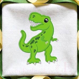 May include: A white fabric square featuring an embroidered green dinosaur with dark green spots, white teeth, and white claws. The dinosaur is positioned in the center of the fabric, which is framed by a border of green and yellow ribbon trim.