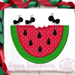 May include: A white background with a watermelon slice design. The watermelon is red with black seeds and a green rind. Three black ants are on top of the watermelon. The text "Joyous Embroidery" and "JOY EMB" are at the bottom.