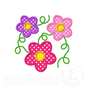 May include: An embroidery design featuring three five-petaled flowers with white polka dots. One flower is purple, one is light pink, and one is dark pink. Each flower has a yellow center and is connected by green swirling vine stems.