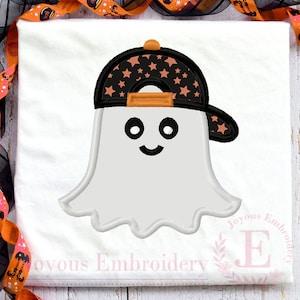 May include: A white t-shirt featuring an embroidered design of a white ghost wearing a black baseball cap with orange stars. The ghost has black circular eyes and a curved black mouth. The text Joyous Embroidery is printed in the bottom corner.