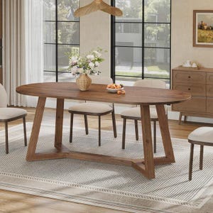 Puede incluir: Una mesa de comedor ovalada de madera con acabado marrón oscuro y una base de caballete resistente. La mesa está rodeada por cuatro sillas con asientos tapizados en beige claro y marcos de madera oscura, sobre una alfombra rectangular de rejilla.