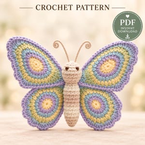 May include: A crochet pattern PDF instant download featuring a butterfly with a cream-colored body and antennae. The wings display concentric circles in shades of yellow, light blue, and lavender with a scalloped purple border.