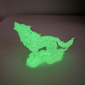 May include: A glow-in-the-dark figurine of a wolf in a howling pose. The sculpture features a translucent, light green material that emits a bright luminescence, showcasing detailed fur textures and a base that resembles swirling smoke or clouds.