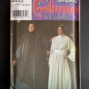 May include: A Simplicity 4443 sewing pattern envelope for adult costumes in size HH 6, 8, 10, 12. The cover features two outfits: a dark, textured long-sleeved gown with a cape and a white, high-necked long-sleeved gown with a wide waistband.