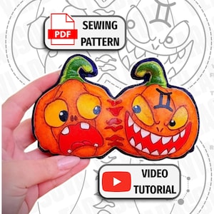 May include: A dual-pumpkin craft piece featuring two orange pumpkins with green stems. One pumpkin has a shocked expression with wide eyes, while the other has a grinning face with sharp teeth and a Gemini symbol. Includes PDF Sewing Pattern and Video Tutorial text labels.
