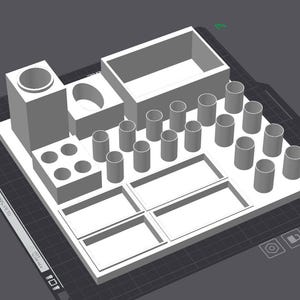 Könnte beinhalten: Ein hellgrauer, 3D-gedruckter Schreibtisch-Organizer mit einem hohen zylindrischen Halter, einem rechteckigen Behälter, einer kleinen ovalen Schale, einem quadratischen Block mit vier runden Löchern und mehreren kleinen zylindrischen Fächern sowie zwei flachen Ablagen.