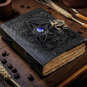 May include: A black leather-bound journal featuring an embossed pentagram design on the cover, centered with a polished blue gemstone. The book includes a brass-colored metal latch closure and thick, deckled-edge pages with a weathered, tan appearance.