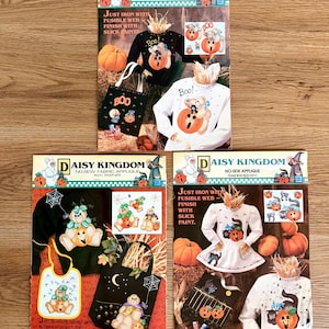 May include: Three Daisy Kingdom no-sew applique craft pattern sheets featuring Halloween designs. Each sheet displays illustrations of pumpkins, cats, and ghosts on clothing and tote bags with instructions to use fusible web and slick paint.