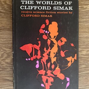 May include: A vintage paperback book titled "THE WORLDS OF CLIFFORD SIMAK." The cover is black with white and orange text. An abstract design in orange, red, and pink adorns the cover. The book is a collection of twelve science fiction stories.