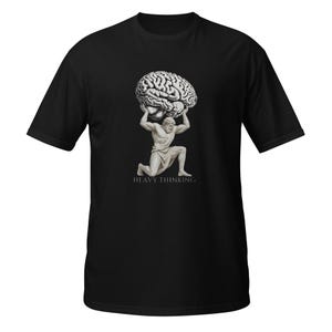 May include: A black short-sleeved t-shirt featuring a graphic of a kneeling classical statue holding a large human brain above its head. Below the figure, the text HEAVY THINKING is printed in a clean, white, sans-serif font.