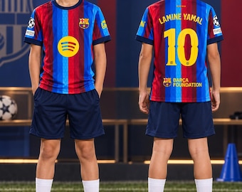 Könnte beinhalten: Ein Fußballtrikot-Set mit einem rot-blau gestreiften Trikot, dem Spotify-Logo, dem FC Barcelona-Wappen sowie dem Namen Lamine Yamal und der Nummer 10 auf der Rückseite. Das Set umfasst dunkelblaue Shorts, weiße Socken und weiße Fußballschuhe.