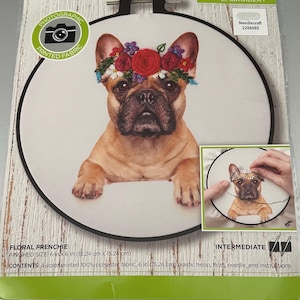 Op de afbeelding: Floral Frenchie stempelborduurpakket. De set bevat een plastic borduurring van 15,24 cm, garen, een naald en instructies. Het ontwerp toont een Franse bulldog met een bloemenkrans. De afgewerkte maat is 15,24 cm x 15,24 cm.