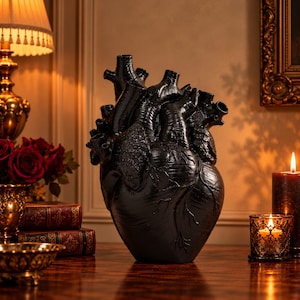 Op de afbeelding: Een matzwart anatomisch hartsculptuur met gedetailleerde aderen, slagaders en kamers. Het beeld is uitgevoerd in een realistische stijl met een gladde, donkere afwerking, die de complexe structuur van een menselijk hart in vaste vorm toont.