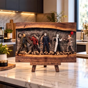 May include: A rectangular live-edge wood display piece featuring five horror movie character figurines standing on a bed of small skulls. The figures include Jason Voorhees, Freddy Krueger, Michael Myers, Art the Clown, and Pennywise.