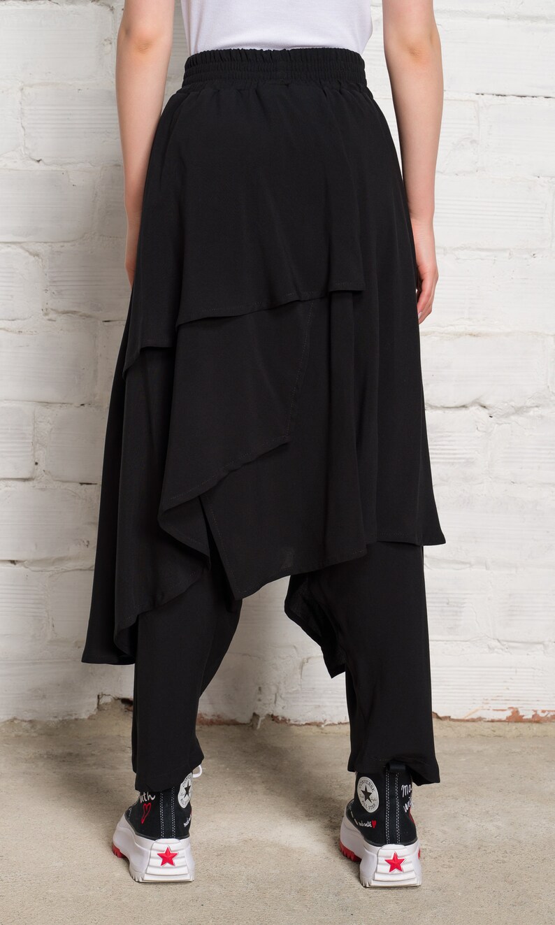 Pode incluir: Saia preta em camadas com um design assim&eacute;trico &uacute;nico. A saia tem uma cintura larga e chega aos tornozelos. A saia &eacute; feita de um tecido leve e &eacute; perfeita para um look casual ou elegante.