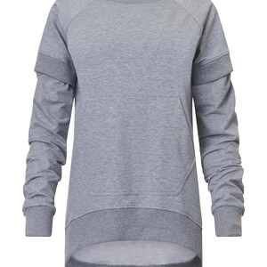 May include: A gray long-sleeved sweatshirt with a kangaroo pocket and a slightly longer back hem.