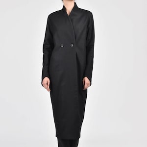 May include: A long black coat with a double-breasted closure and a wide collar.