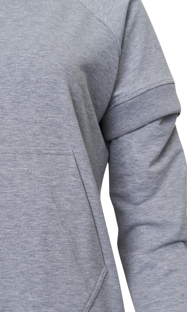 May include: A gray long-sleeved sweatshirt with a raglan sleeve design and a kangaroo pocket. The sweatshirt has a ribbed cuff and hem.