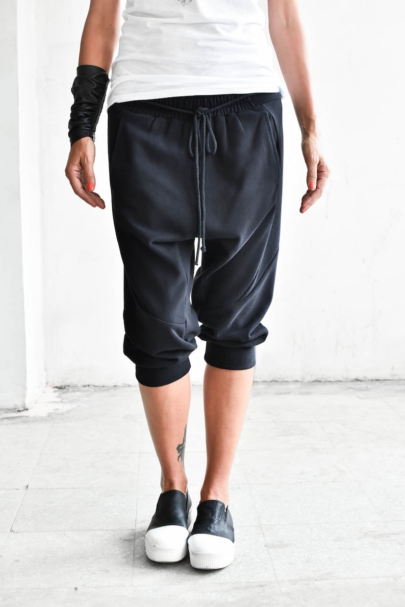 May include: Black cropped pants with a drawstring waist and a relaxed fit.