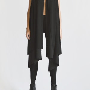 May include: A black sleeveless top with a long, draped scarf. The scarf is folded and layered, creating a unique and stylish look.