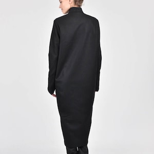 May include: A black long-sleeved dress with a high neck and a long, flowing skirt. The dress is made of a soft, comfortable fabric and has a relaxed fit.