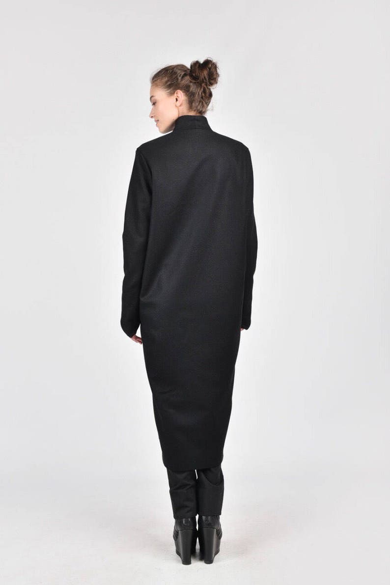 May include: A black long-sleeved dress with a high neck and a long, flowing skirt. The dress is made of a soft, comfortable fabric and has a relaxed fit.