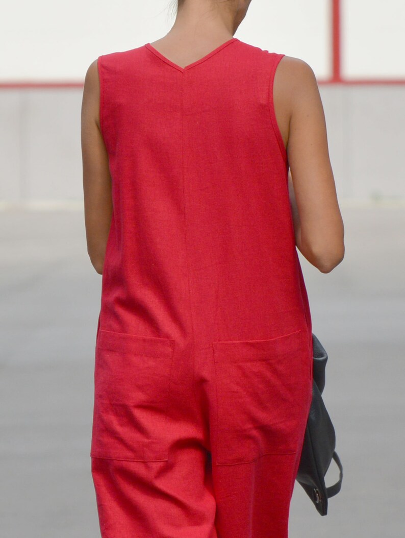 May include: A sleeveless red jumpsuit with a V-neckline and two pockets on the back.
