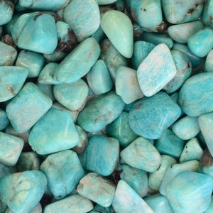 May include: A collection of smooth, polished amazonite stones in various shades of blue-green. The stones are tumbled and have a natural, organic look.