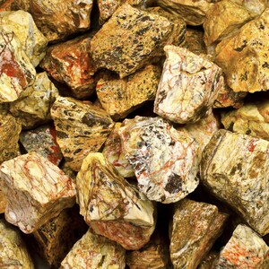 Pode incluir: Um close-up de um monte de pedras amarelas, marrons e vermelhas. As pedras têm um padrão de mármore e são de forma irregular.