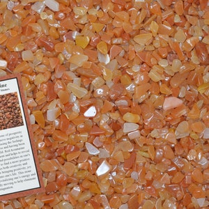 May include: A close-up image of a pile of small, red, orange, and white tumbled stones. The stones are labeled as Red Aventurine, Home Decor / Healing Stones. The text on the card describes the stone's properties and benefits.