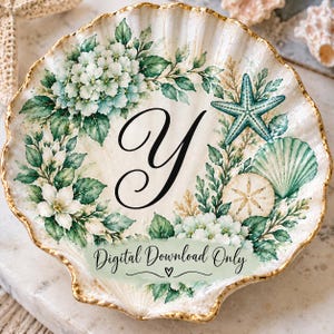 Puede incluir: Un plato decorativo en forma de concha con borde dorado, una letra Y negra en el centro y una ilustración de hortensias blancas, hojas verdes, una estrella de mar turquesa y un dólar de arena. El texto dice Digital Download Only.