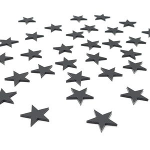 May include: A scattering of black star-shaped decorations on a white background.