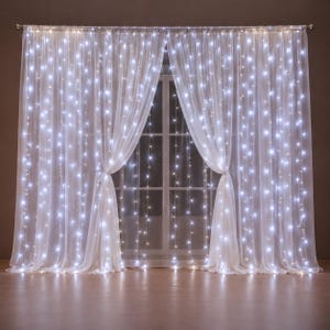 Op de afbeelding: Transparante witte gordijnen aan een roede, voorzien van geïntegreerde verticale strengen met heldere koelwitte LED-lichtjes. De doorschijnende stof is in zachte plooien gedrapeerd, wat zorgt voor een stralend en gelaagd effect voor het raam.