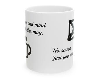 Puede incluir: Una taza de cerámica blanca con texto y gráficos en negro. El texto dice "eyes and mind with this mug." y "No screen Just you and". En la superficie hay impreso un icono negro de una taza de café y un icono negro de una pantalla tachada.