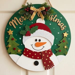 May include: A round green wooden sign featuring a snowman with an orange nose, a red and gold polka dot scarf, and a glittery white hat. The sign displays the text Merry Christmas, flanked by two green pine trees and topped with a gold bow.