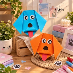 Könnte beinhalten: Zwei Origami-Hundegesichter aus Papier, eines in leuchtendem Blau und eines in kräftigem Orange. Jeder Hund hat große weiße Augen mit schwarzen Pupillen, eine schwarze dreieckige Nase und eine herausgestreckte rote Zunge. Die Papierfiguren sind dreieckig gefaltet und haben Schlappohren.